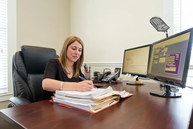 Secretary at desk reviewing documents